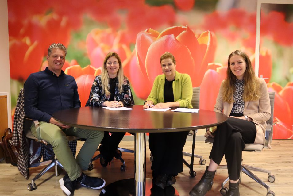 4 mensen in een kantoor met een kleurrijke tulpen achtergrond